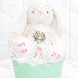 Plush bunny rabbit with 'Happy Easter' text in a green basket on a white background.