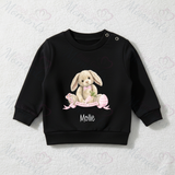 Black sweater with a bunny design and 'Mollie' text on a textured white background