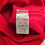 Clothing label on a red fabric with text and symbols.
