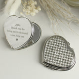 Heart-shaped compact mirror with engraved message on a light background