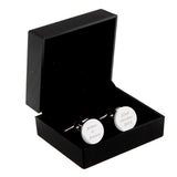 Cufflinks with engraved text in a black box on a white background