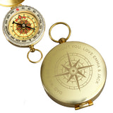 Gold pocket compass with engraved text on a white background