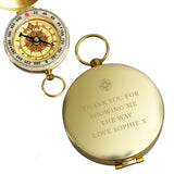 Gold pocket compass with engraved message on a white background