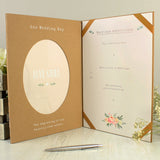 PHoto of the inside of the personalised wedding certificate display book. Standing upright and open on a light wooden table top with silver pen alongside it