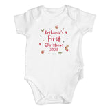 White baby onesie with 'Bethanie's First Christmas 2023' text on a white background