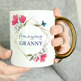 White mug with 'Amazing Granny' text and floral design held by a person.