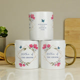 Three white mugs with floral designs and text on a wooden surface.