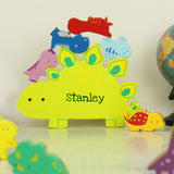 Colorful dinosaur-shaped nameplate with 'Stanley' on a light surface.