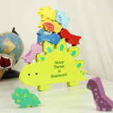 Colorful dinosaur-shaped toy with personalized message on a light surface.