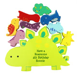 Colorful dinosaur-shaped wooden stacker toys with a large yellow dinosaur in the centre, personalized with text.