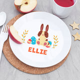 White plate with a cartoon bunny design and the name 'ELLIE' on a cork placemat.