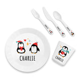 Children's dinnerware set with penguin design and 'Charlie' text on a white background
