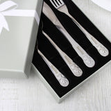 A set of personalized steel cutlery with embossed teddy bear designs, presented in a gift box.