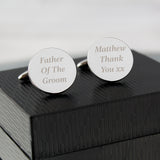 Personalised Round Cufflinks. One cufflink has the words "Father of the Groom" and the other "Matthew Thank You xx" Placed on top of a black gift box
