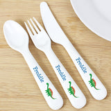 A set of white plastic cutlery including a spoon, fork, and knife, each with a dinosaur design and the name 'Freddie' printed on the handles.