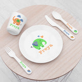 A personalised kids' dining set with an elephant design, including a plate, fork, knife, and spoon, all with a white base color and colorful elephant decorations.