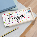 A personalized wooden pencil box with a colorful polka dot pattern and the name 'Freya' written on the front.